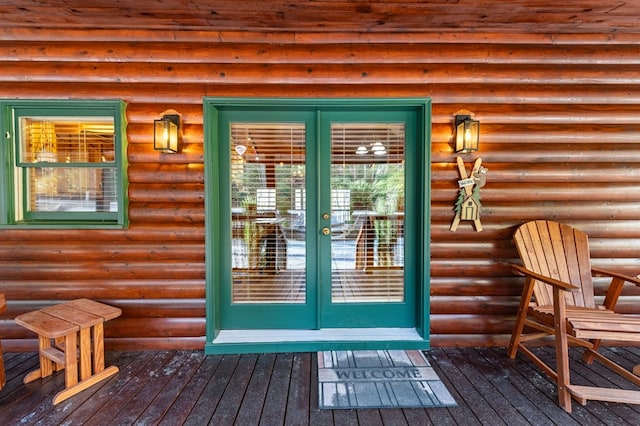 view of exterior entry with a deck and french doors