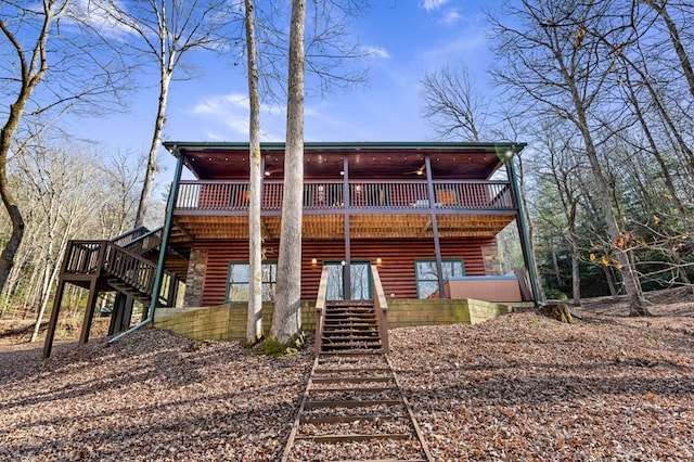 back of property with stairs, a deck, and log veneer siding