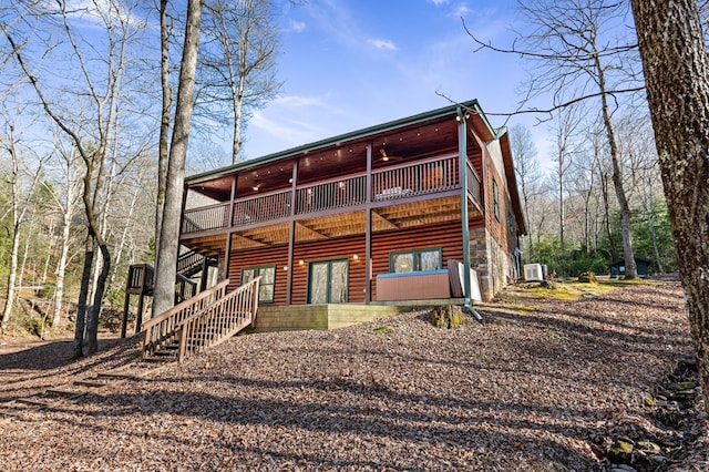 back of property featuring stairway, a deck, a ceiling fan, and log veneer siding