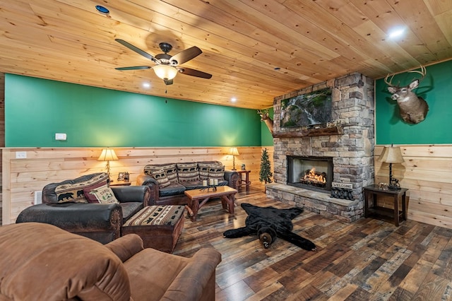 living area with a wainscoted wall, wood walls, a fireplace, wood finished floors, and wood ceiling