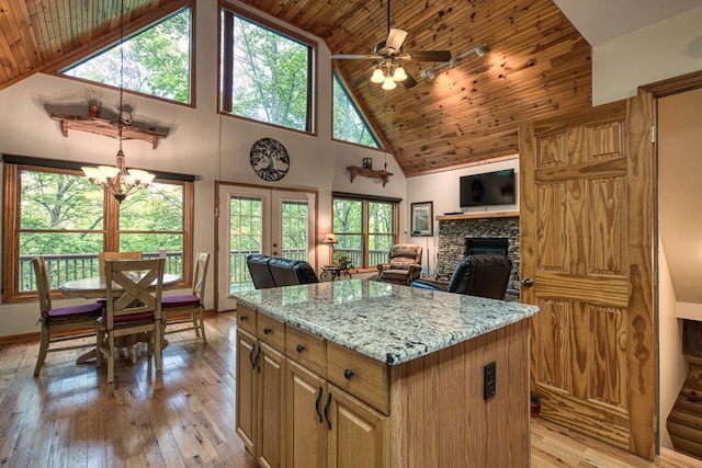 kitchen with high vaulted ceiling, wood ceiling, healthy amount of natural light, a fireplace, and light wood finished floors