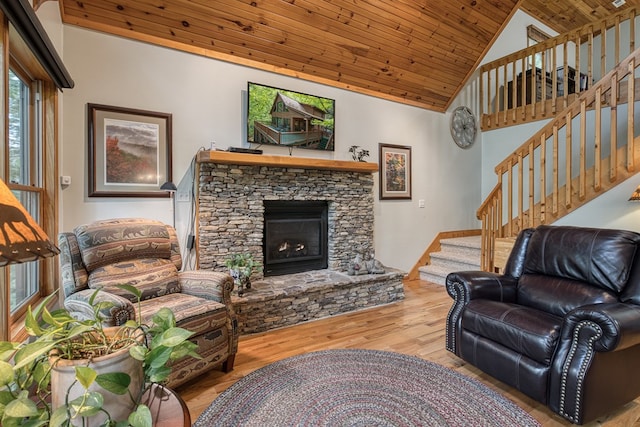 living area with wood ceiling, stairs, wood finished floors, a fireplace, and high vaulted ceiling