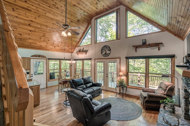 living area with high vaulted ceiling, a ceiling fan, light wood-style floors, plenty of natural light, and french doors