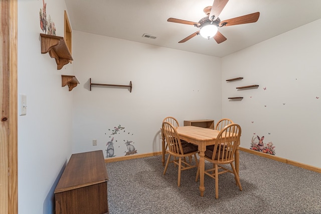 carpeted dining room with a ceiling fan and baseboards