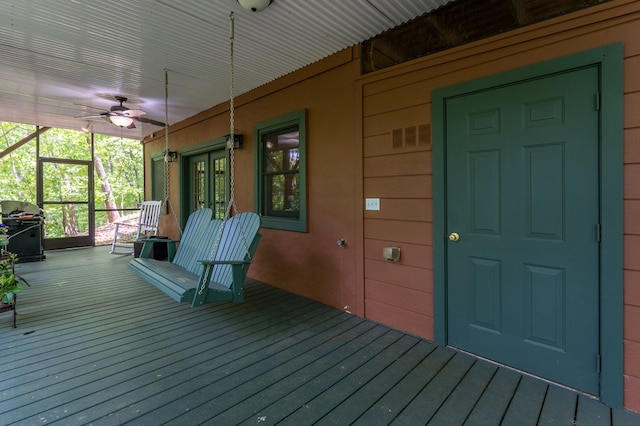 wooden porch with a ceiling fan and a grill