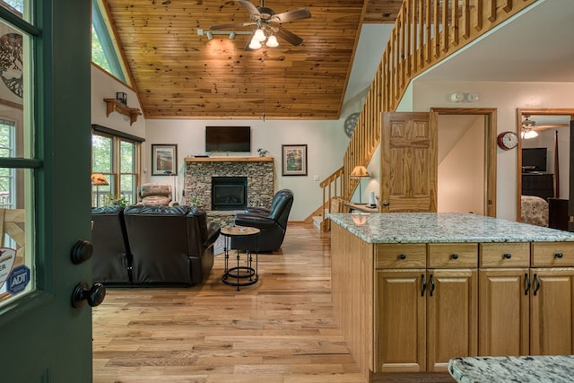 living area with high vaulted ceiling, ceiling fan, stairs, wooden ceiling, and light wood-type flooring