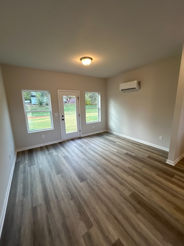 empty room featuring dark hardwood / wood-style floors and an AC wall unit