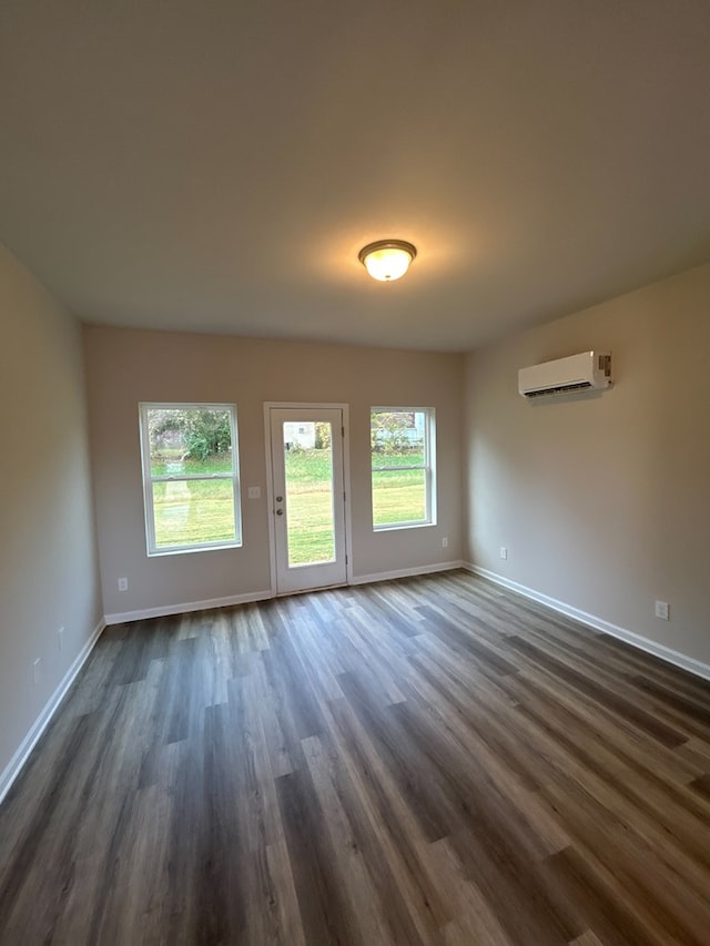 interior space with dark wood-type flooring and a wall mounted air conditioner