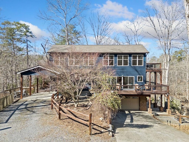 view of front of house with driveway, a balcony, an attached garage, and brick siding