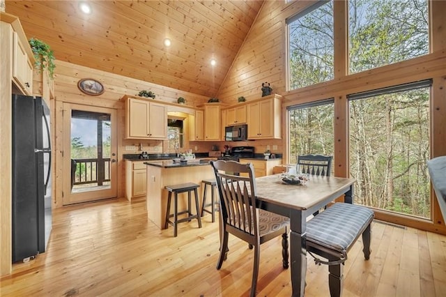 dining area featuring wooden walls, high vaulted ceiling, light hardwood / wood-style floors, and wood ceiling