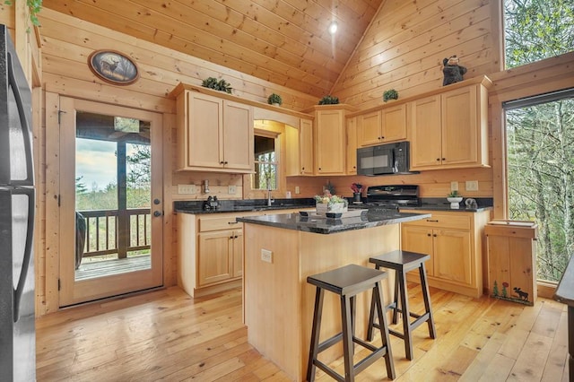 kitchen with stove, light hardwood / wood-style floors, a center island, and a wealth of natural light