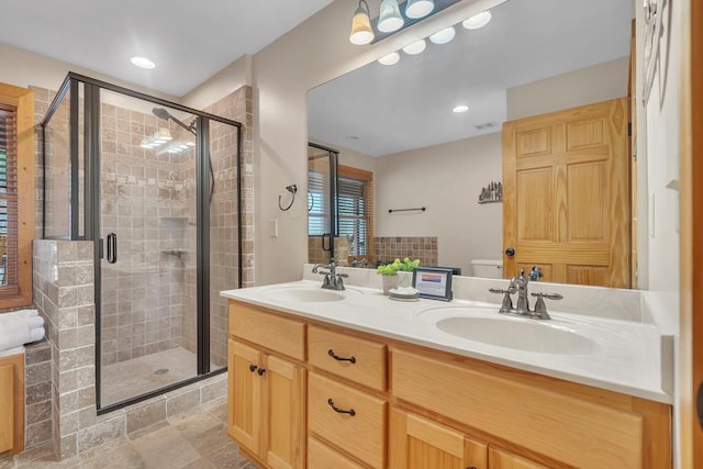 bathroom featuring tile flooring, dual sinks, large vanity, and a shower with shower door