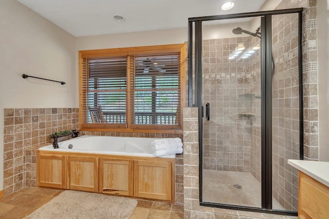 bathroom with tile floors, separate shower and tub, and vanity