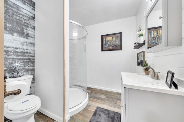 bathroom with toilet, vanity with extensive cabinet space, walk in shower, and hardwood / wood-style flooring