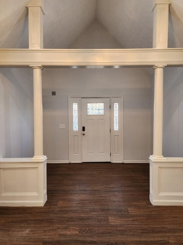 foyer with high vaulted ceiling, decorative columns, and dark hardwood / wood-style floors