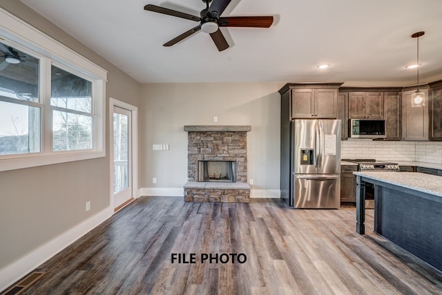 kitchen with pendant lighting, wood-type flooring, stainless steel appliances, and tasteful backsplash