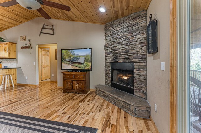 living area featuring a ceiling fan, wooden ceiling, wood finished floors, and a fireplace