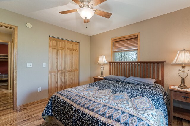 bedroom featuring a closet, ceiling fan, baseboards, and light wood-type flooring