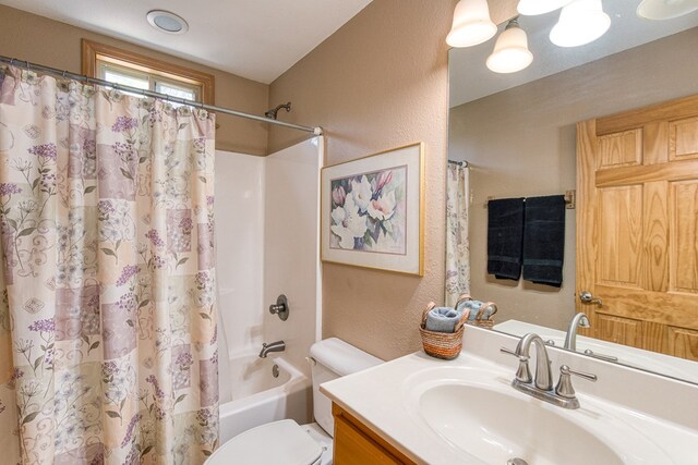 full bathroom with toilet, a textured wall, shower / tub combo with curtain, and vanity