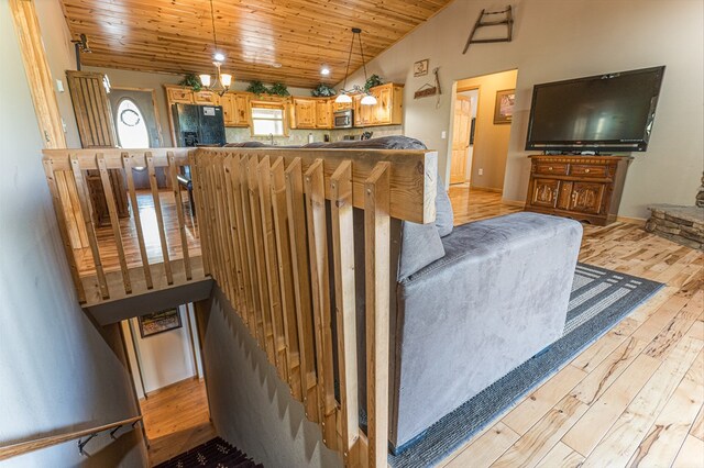living area with light wood-style flooring, lofted ceiling, and wooden ceiling