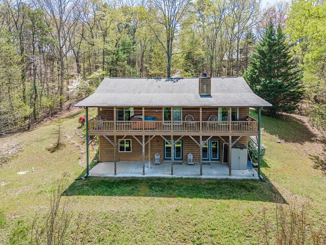 back of property with a patio, a chimney, a yard, and a deck