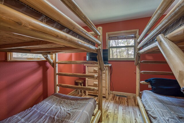 bedroom with baseboards and wood-type flooring
