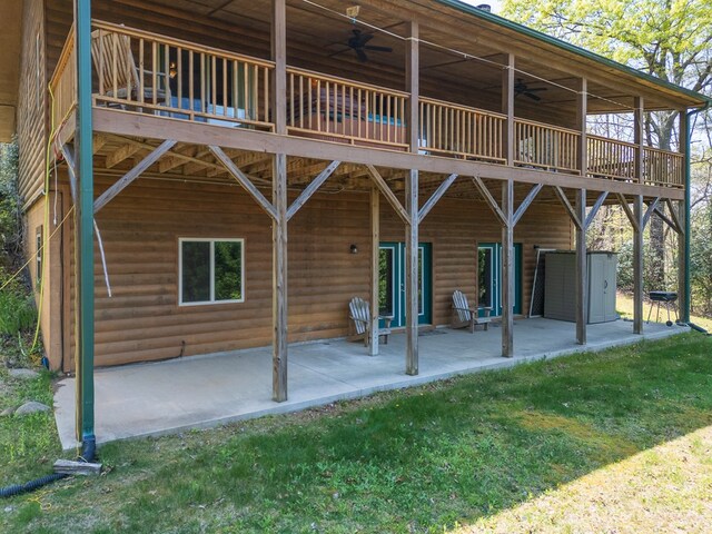 rear view of property featuring a ceiling fan, a patio area, a wooden deck, and faux log siding