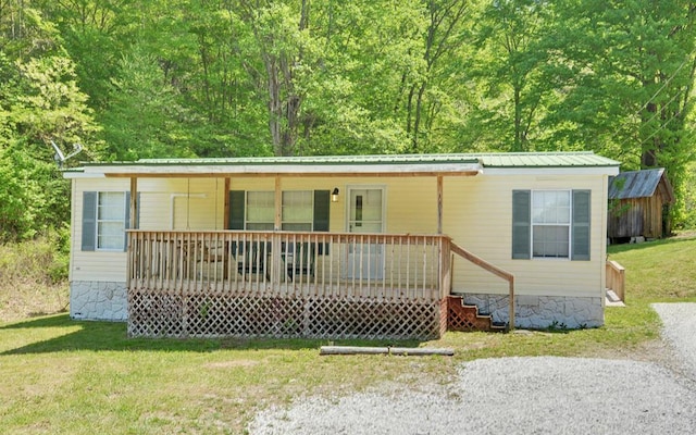 manufactured / mobile home featuring a front lawn, covered porch, and metal roof