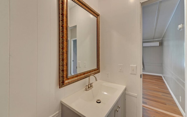 bathroom featuring vanity, a wall mounted AC, and wood finished floors