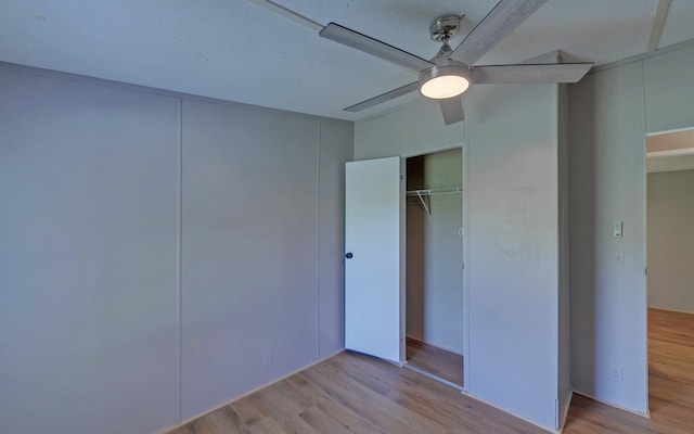 unfurnished bedroom featuring ceiling fan, wood finished floors, and a closet
