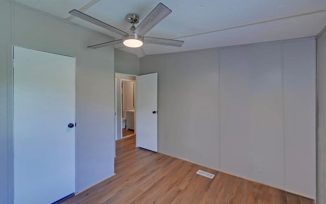 unfurnished bedroom featuring visible vents, a ceiling fan, and wood finished floors