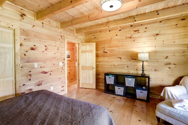 bedroom with light wood-style floors, wood ceiling, beam ceiling, and wooden walls