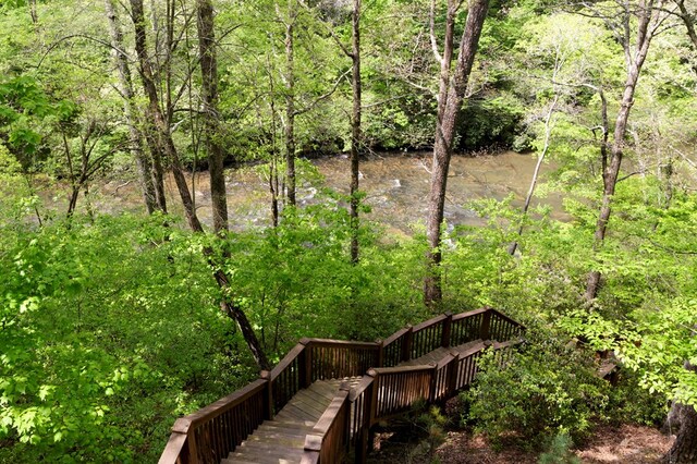 view of community featuring a wooded view and a wooden deck
