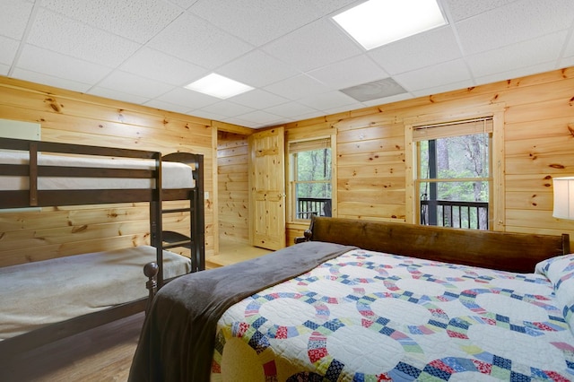 bedroom featuring wood finished floors and wooden walls