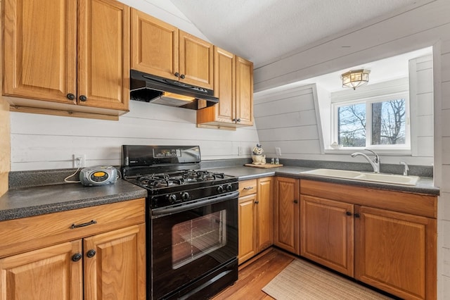 kitchen with black range with gas cooktop, light hardwood / wood-style floors, a textured ceiling, and sink