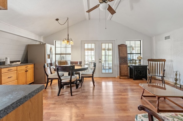 dining area featuring french doors, light hardwood / wood-style floors, lofted ceiling with beams, and ceiling fan with notable chandelier