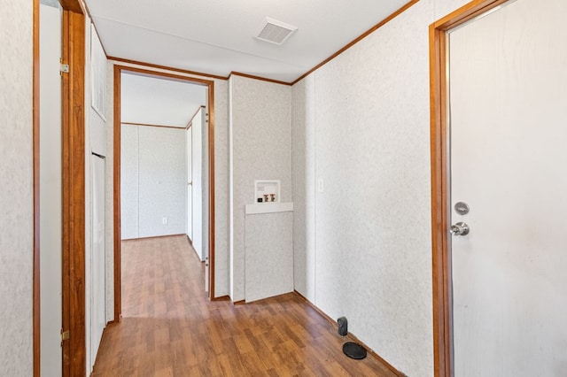 corridor with crown molding, dark hardwood / wood-style flooring, and a textured ceiling