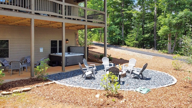 view of patio with a hot tub, an outdoor fire pit, and a wooden deck