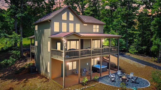 rear view of property with a balcony, cooling unit, and a patio