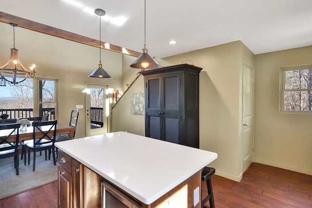 kitchen with a wealth of natural light, pendant lighting, and dark wood-type flooring