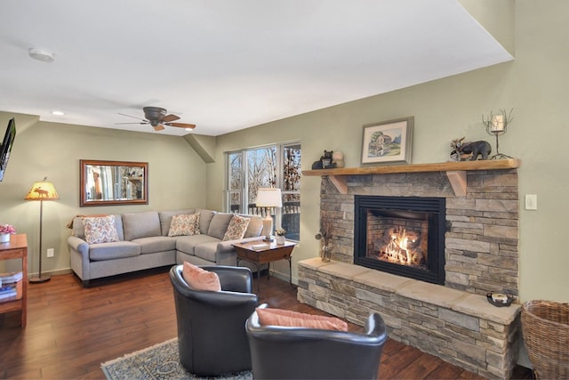 living room featuring a stone fireplace, ceiling fan, and dark hardwood / wood-style flooring