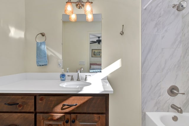 bathroom featuring vanity, tiled shower / bath, and ceiling fan