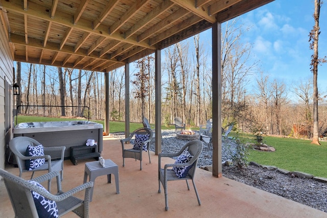 view of patio / terrace with a fire pit and a hot tub