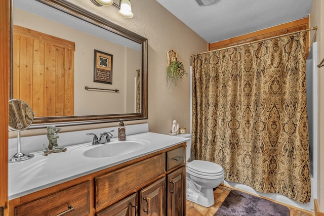 bathroom with vanity, toilet, and a textured ceiling