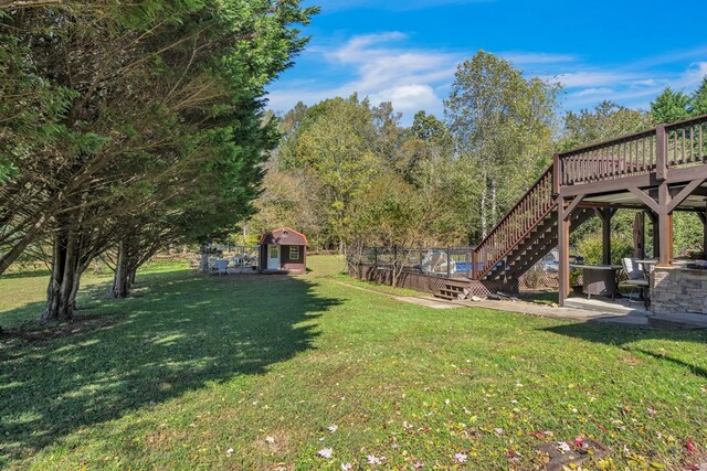 view of yard featuring a wooden deck and a storage unit