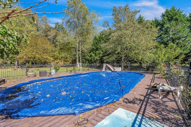 view of pool featuring a water slide and a deck