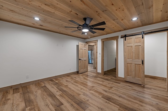 74 Cohutta Overlook Way, Blue Ridge, GA 30513 - unfurnished bedroom featuring freestanding refrigerator, a barn door, baseboards, wooden ceiling, and light wood-style flooring