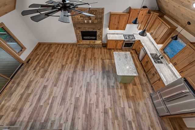 74 Cohutta Overlook Way, Blue Ridge, GA 30513 - unfurnished living room featuring wood finished floors, a stone fireplace, ceiling fan, and baseboards