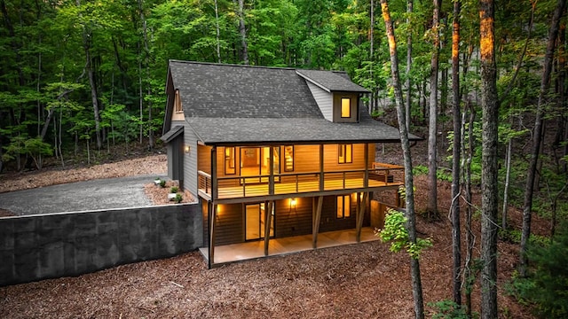 74 Cohutta Overlook Way, Blue Ridge, GA 30513 - rear view of property featuring a forest view, driveway, roof with shingles, a patio area, and a wooden deck