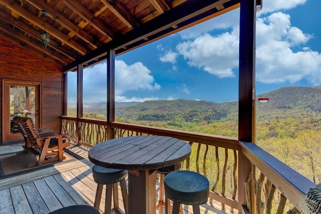 deck featuring a mountain view and a wooded view